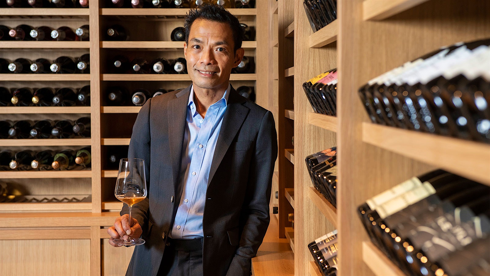 Portrait of Ron Acierto in a modern-looking wine cellar.